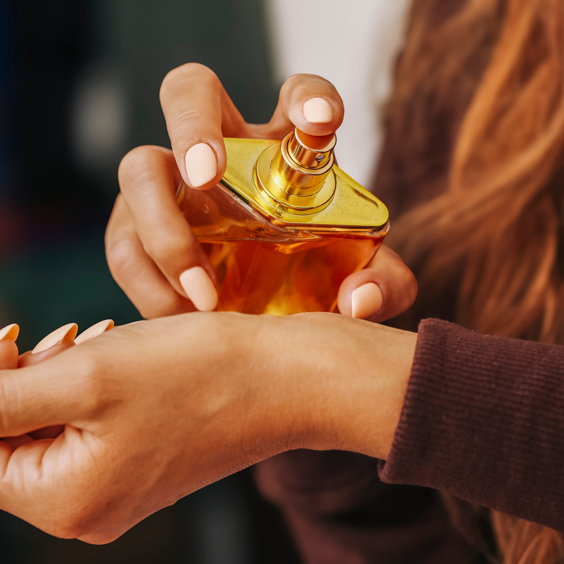 woman applying perfume on wrist